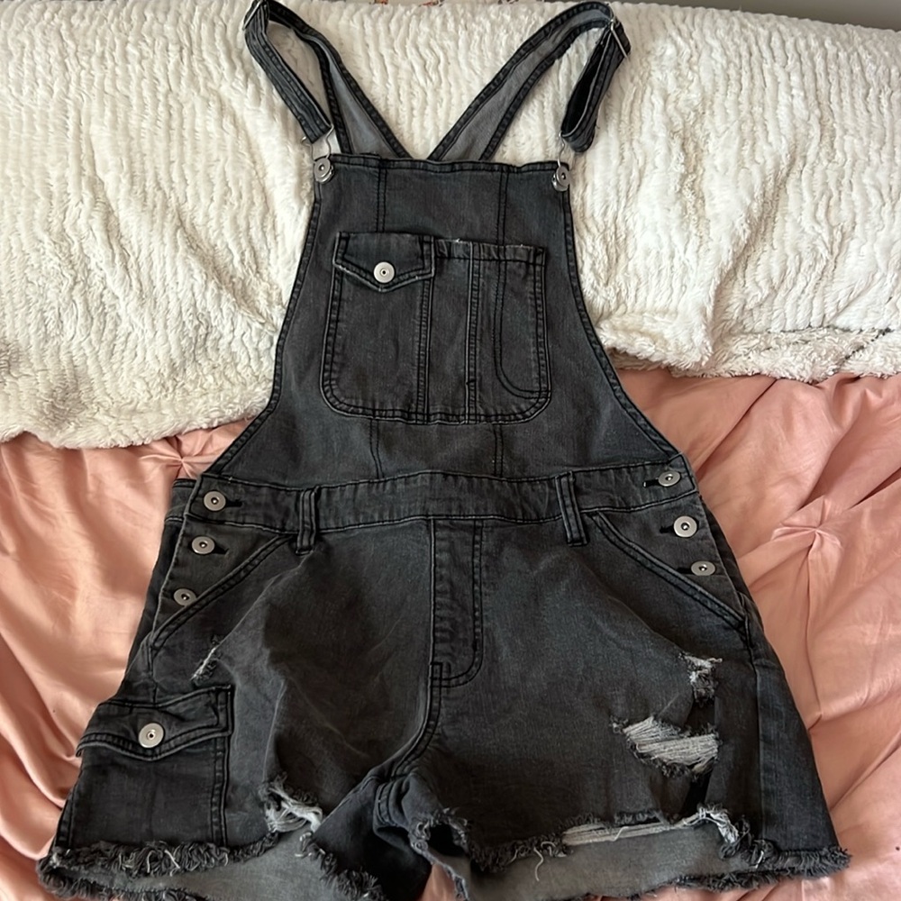 Dark gray jean overalls, with rips on the shorts, has buttons on side & pockets